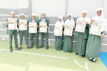 Students of I Scholars International Academy holding copies of Teen Trust